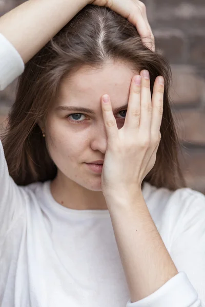 Молодая женщина смотрит сквозь пальцы — стоковое фото