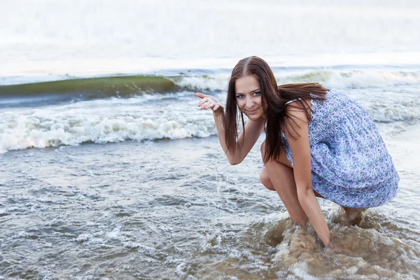 Arka plan dalgalar üzerinde genç kadın — Stok fotoğraf