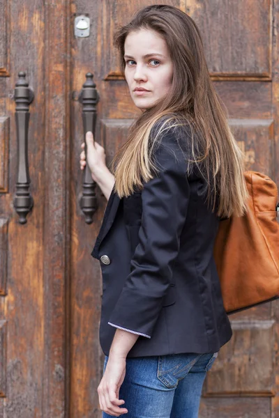 Young woman near old door — Stock Photo, Image