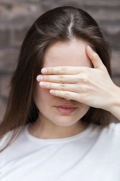 Kobieta ukrywa jej twarzy dłoni — Zdjęcie stockowe