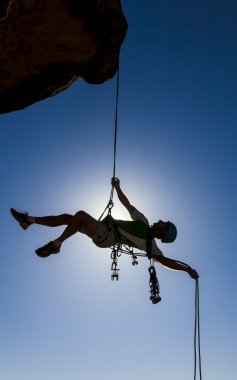 Climber rappelling from the summit. clipart