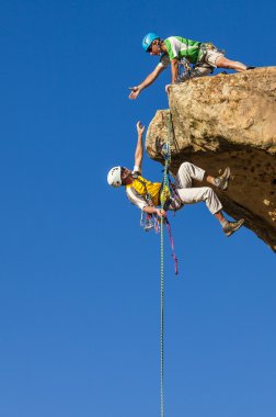 Climbing team struggles to the summit. clipart