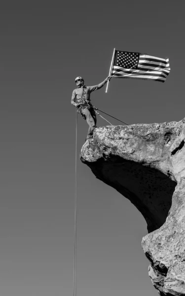 Альпинист машет флагом на вершине . — стоковое фото