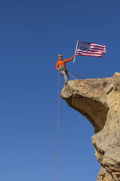 Bergsteiger schwenkt Fahne auf dem Gipfel. — Stockfoto