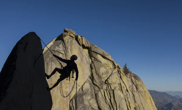 Bergsteiger seilt sich vom Gipfel ab. — Stockfoto