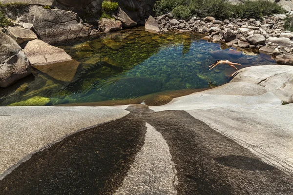 Genç kadın prestine dağ havuza dalışlar. — Stok fotoğraf