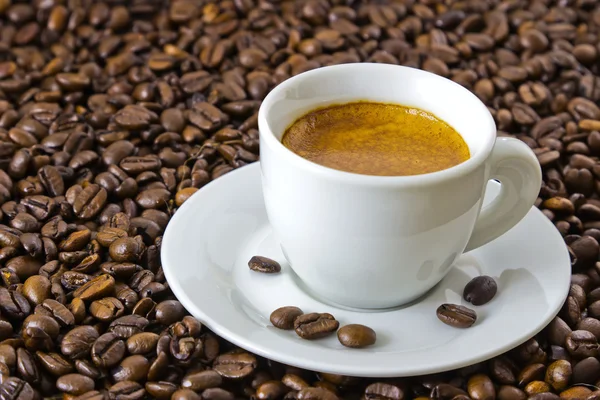 Fresh espresso at roasted coffee beans — Stock Photo, Image