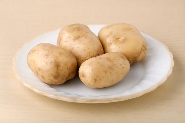 Свежий картофель на белой тарелке — стоковое фото