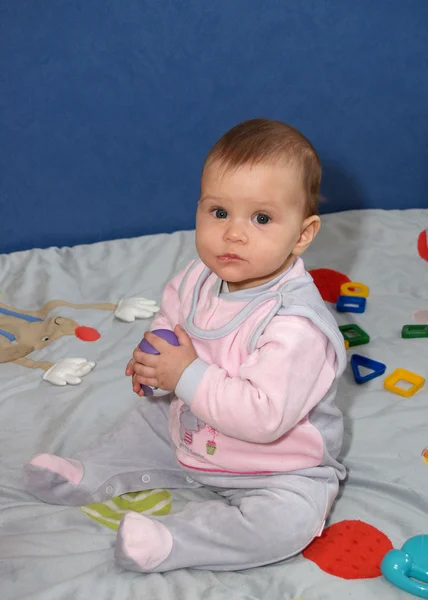Het kleine meisje houdt een stuk speelgoed — Stockfoto