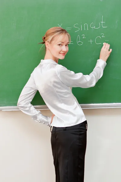 Lehrerin schreibt an Tafel — Stockfoto