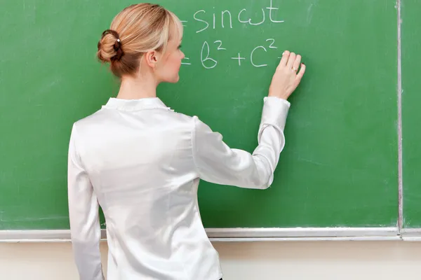 Вчитель пише на дошці формули — стокове фото