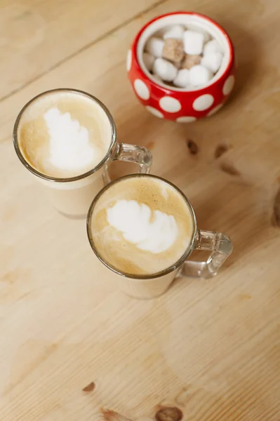 Кофе-латте в двух высоких стаканах и сахарной чашке, мелкий dof — стоковое фото