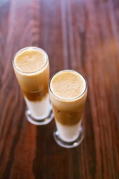 Latte de café gelado na mesa de madeira em copos altos — Fotografia de Stock
