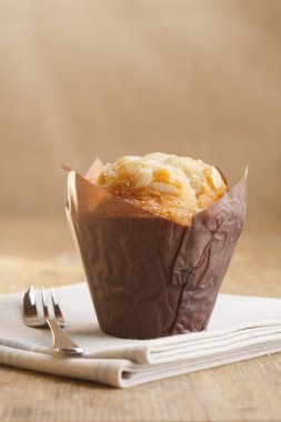 Bademli muffin rustik tarzda pasta çatal ile sarılmış.