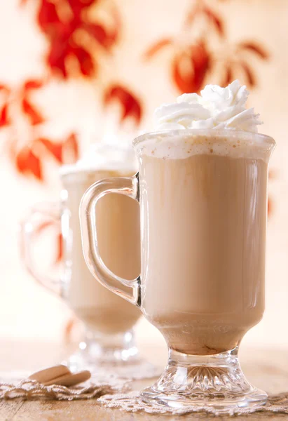 Café con leche macchiato con crema en vasos sobre hojas backgroun —  Fotos de Stock