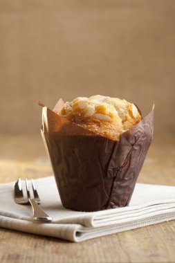 Bademli muffin rustik tarzda pasta çatal ile sarılmış.