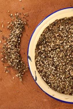 Zaatar- a blend of herbs, sesame seeds and salt in an old ename clipart