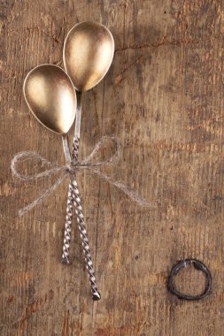 Two retro desset spoons tied on old wooden table clipart