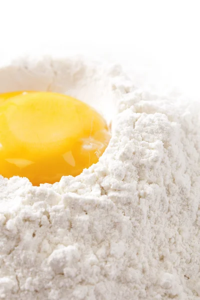 Ψήνουμε! κρόκο αυγού σε αλεύρι, λευκό φόντο — Stockfoto