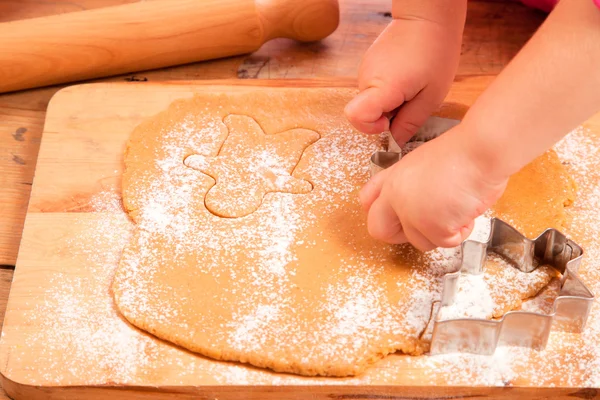 Little girl with cutter make a gingerbread man cookie — Stock Photo, Image