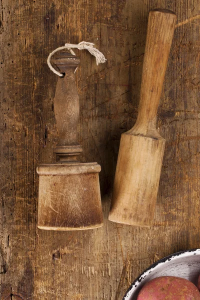 Antike Kartoffelstampfer auf sehr altem Holztisch — Stockfoto