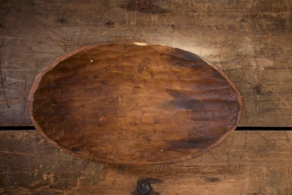 Old handmade carved wooden bowl on old table — Stock Photo, Image