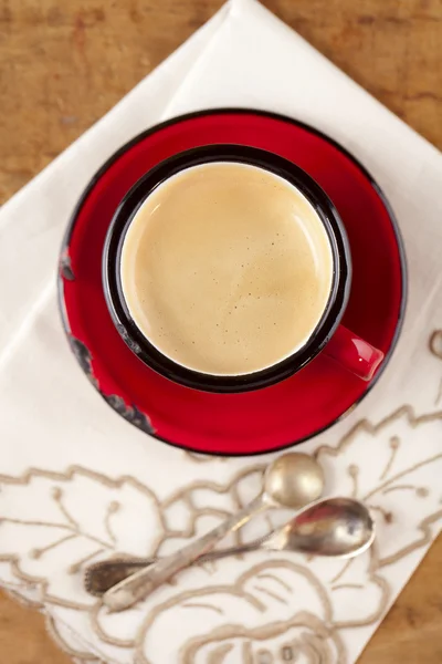 Espressokoffie in rood glazuur mok, twee oude zilveren lepels, embroi — Stockfoto