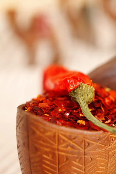 Röda chilifrukter papper i böjda träskål och kamel karavan silhuetten — Stockfoto