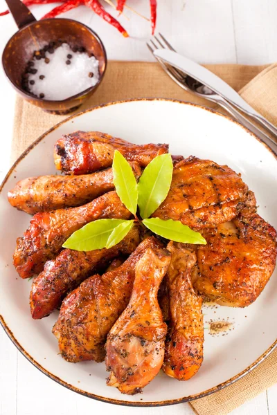 Homemade smoked chicken drumsticks and thighs on a plate — Stock Photo, Image