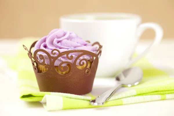 Cupcake avec glaçage à la lavande dans un emballage festif et tasse à café — Photo
