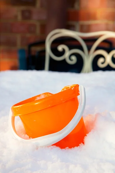 stock image Brigth summer bucket in snow drift with garden background