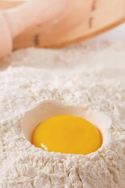 Egg yolk in flour, rolling pin ang sieve on background — Stock Photo, Image