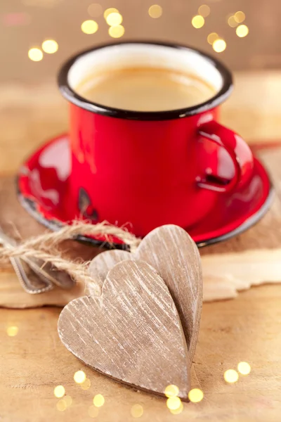 Café expreso, taza de esmalte rojo, dos corazones de madera y festivo —  Fotos de Stock