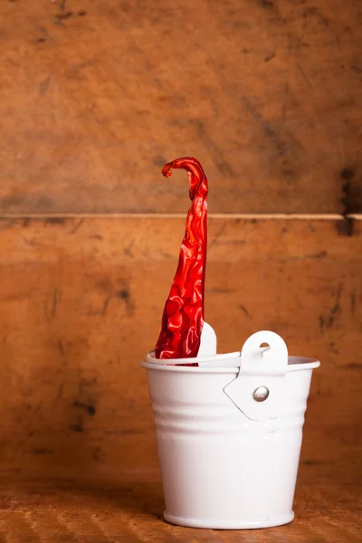 Rode hete pepers papier in glazuur emmer in houten doos — Stockfoto