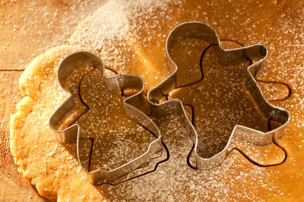 Gingerbread boy and girl cokkies cutters on rolling dough — Stock Photo, Image