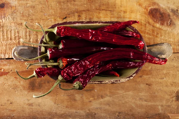 Sušené červené horké chilli papričky ve staré dřevěné míse, mělké dof — Stock fotografie