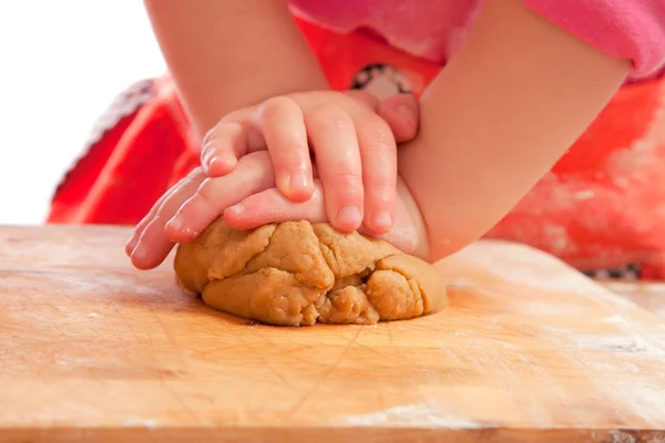 Kleines Mädchen knetet Lebkuchenteig nur mit den Händen — Stockfoto