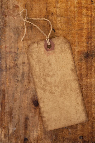Vecchio cartellino di carta con stringa su tavolo in legno grunge — Foto Stock