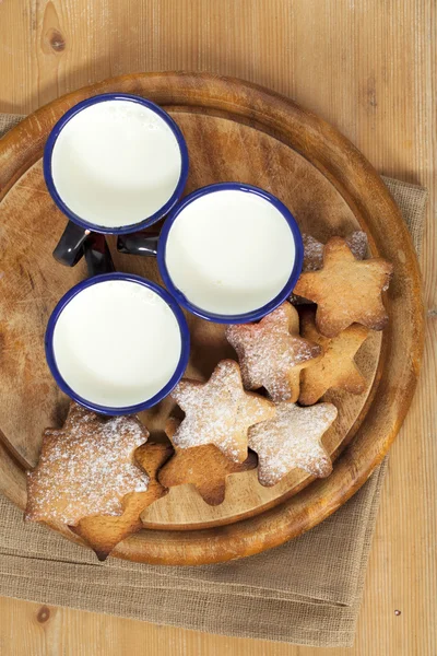 Biscotti fatti in casa di pan di zenzero stella con tre bambini latte su legno — Foto Stock