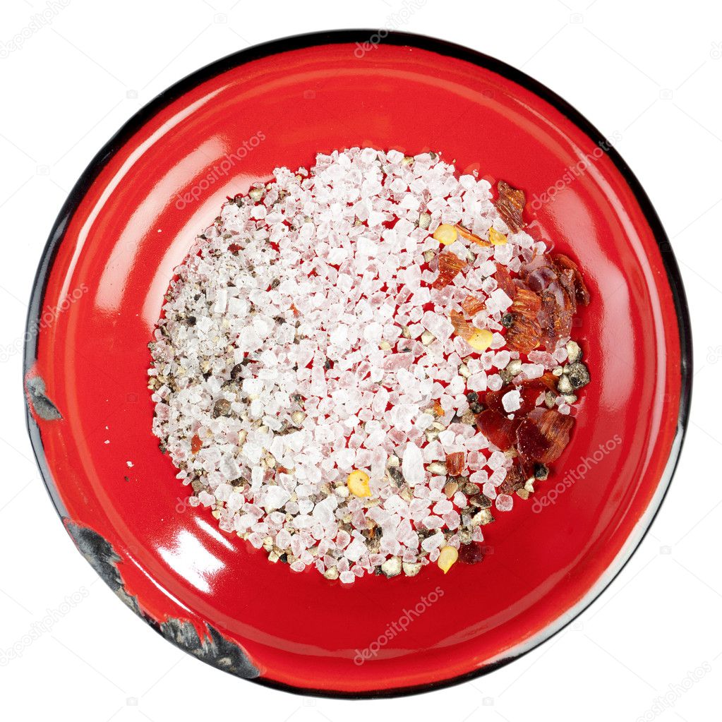 Seasoned sea salt in enamel red plate, isolated