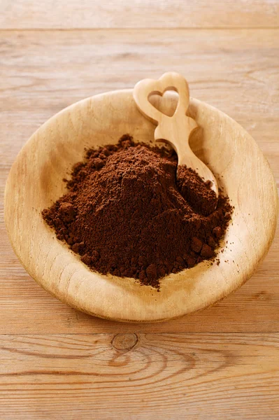 Polvere di caffè macinato in piatto di legno con cucchiaio a forma di cuore, sha — Foto Stock