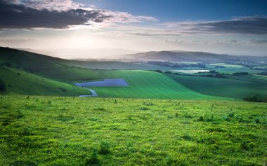 Beautiful English countryside landscape over rolling hills clipart