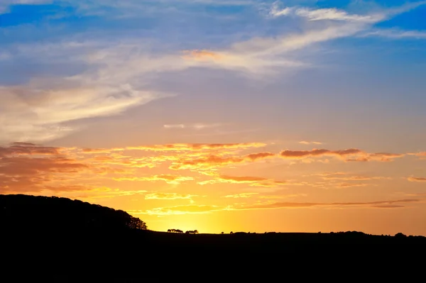 Ohromující západu slunce obloha s silueta krajina horizontem — Stock fotografie