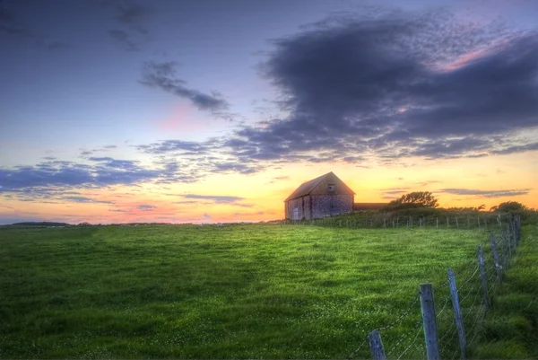 Ancienne grange dans le paysage au coucher du soleil — Photo