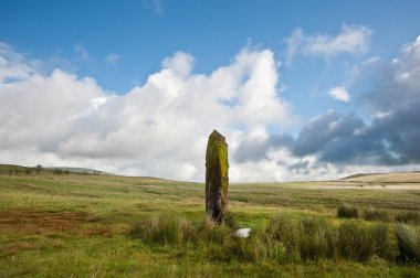 Prehistoric anicent stone in landscape against blue sky clipart