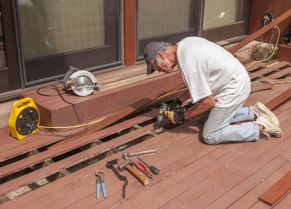 Senior repairing wood deck — Stock Photo, Image
