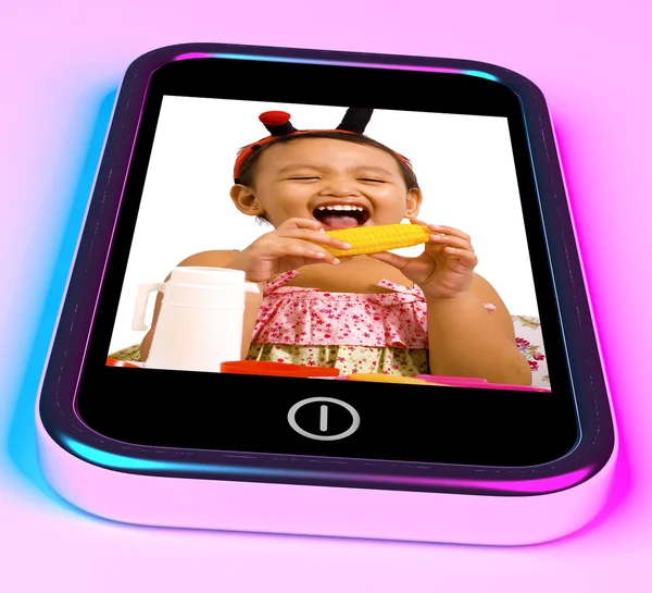 Meisje met speelgoed foto op mobiele telefoon — Stockfoto