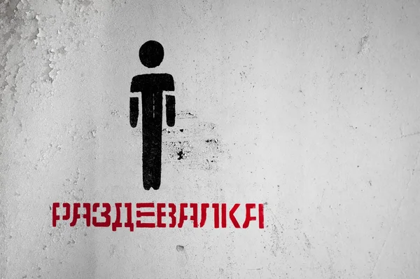 Černá postava na bílé zdi s ruským textem — Stock fotografie