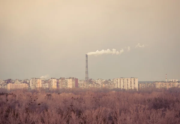 Gran chimenea en medio de una ciudad con cielo — Foto de Stock
