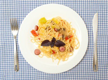 Spagetti with zucchini, mushrooms, sauce, cheese, sausage on a plate. clipart